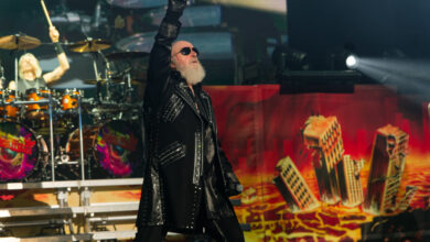 Judas Priest performing live at Shoreline Amphitheatre in Mountain View, California — Rob Halford leading the crowd beneath a wall of flames and lights.