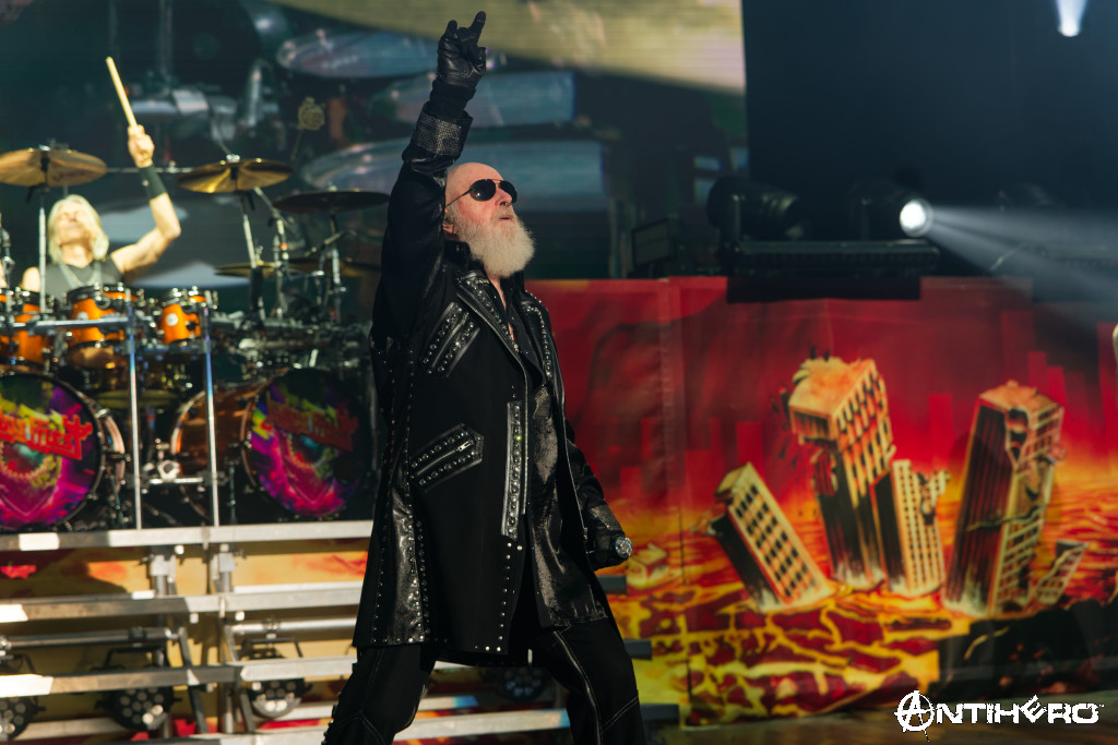 Judas Priest performing live at Shoreline Amphitheatre in Mountain View, California — Rob Halford leading the crowd beneath a wall of flames and lights.